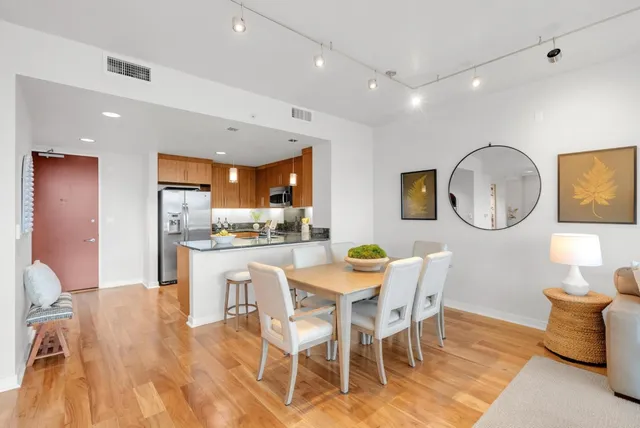 a dining room with wooden floor a glass table and chairs