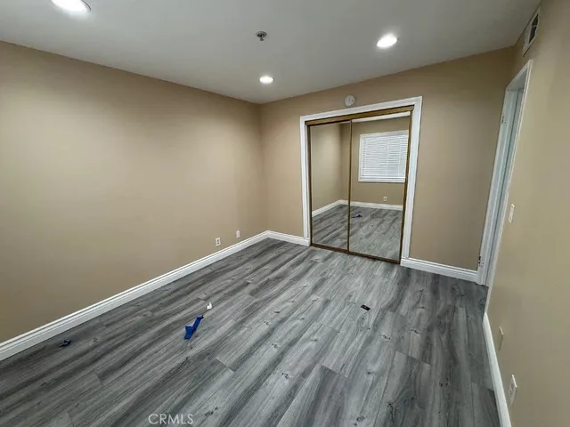 an empty room with wooden floor and window