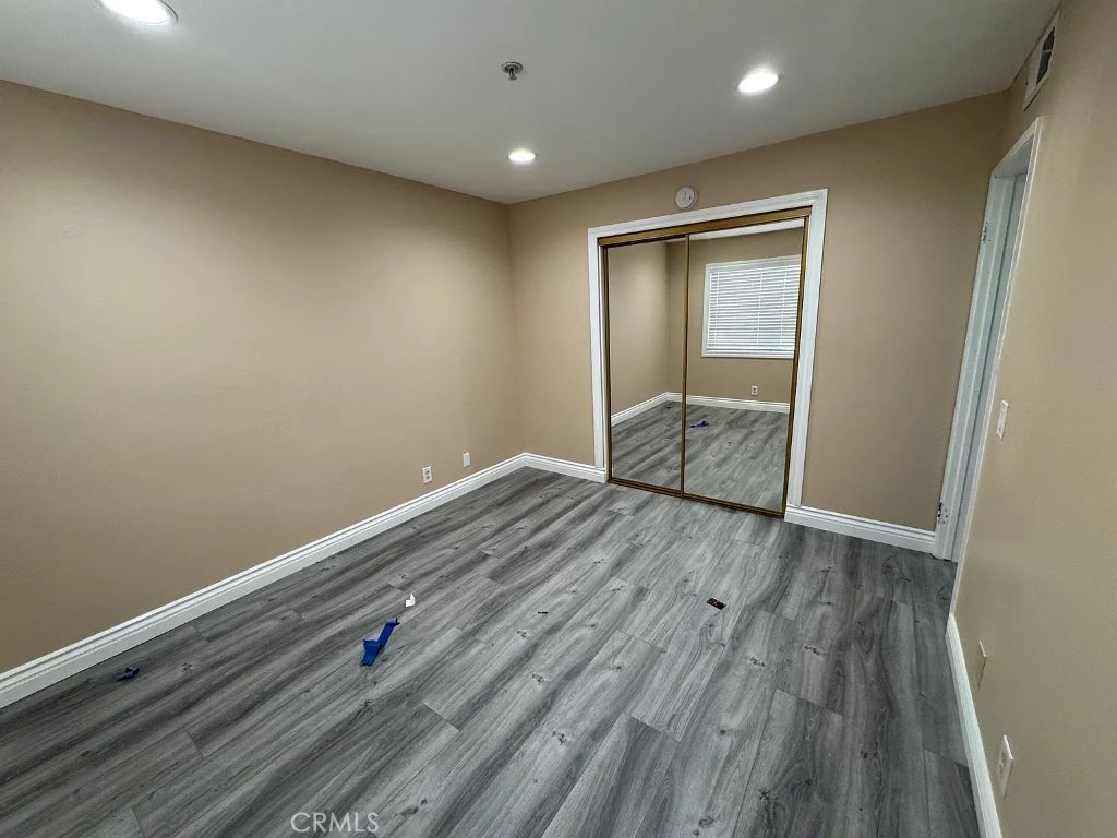 3880 West Jacinto View Road, Unit M Banning, CA 92220 - Photo 6 of 12 an empty room with wooden floor and window