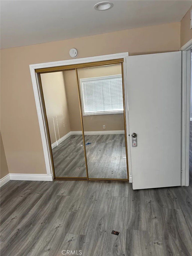 3880 West Jacinto View Road, Unit M Banning, CA 92220 - Photo 9 of 12 a view of an empty room with wooden floor and a window