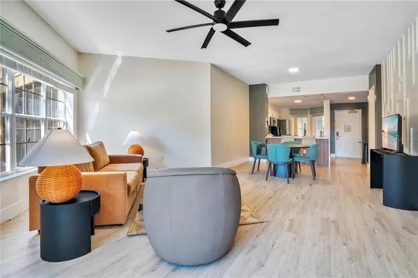 a living room with furniture and a dining table with wooden floor