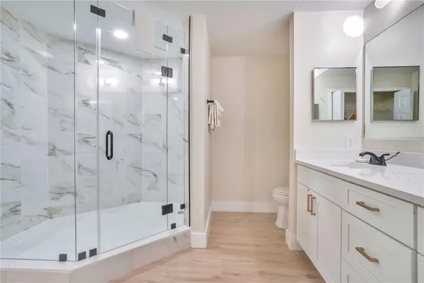 a bathroom with a sink a toilet and shower