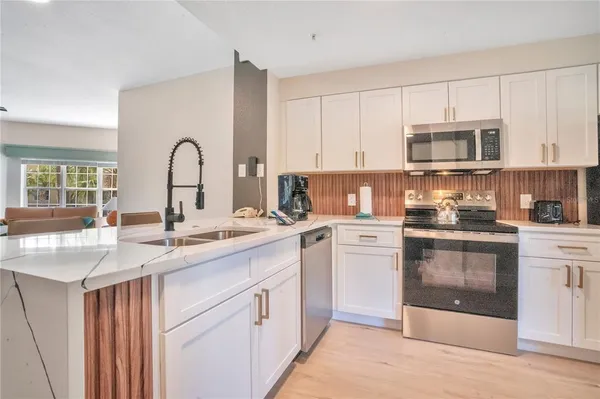 a kitchen with stainless steel appliances granite countertop a sink and cabinets