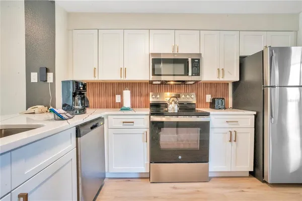 a kitchen with white cabinets and stainless steel appliances