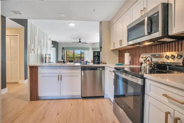 a kitchen with white cabinets and appliances