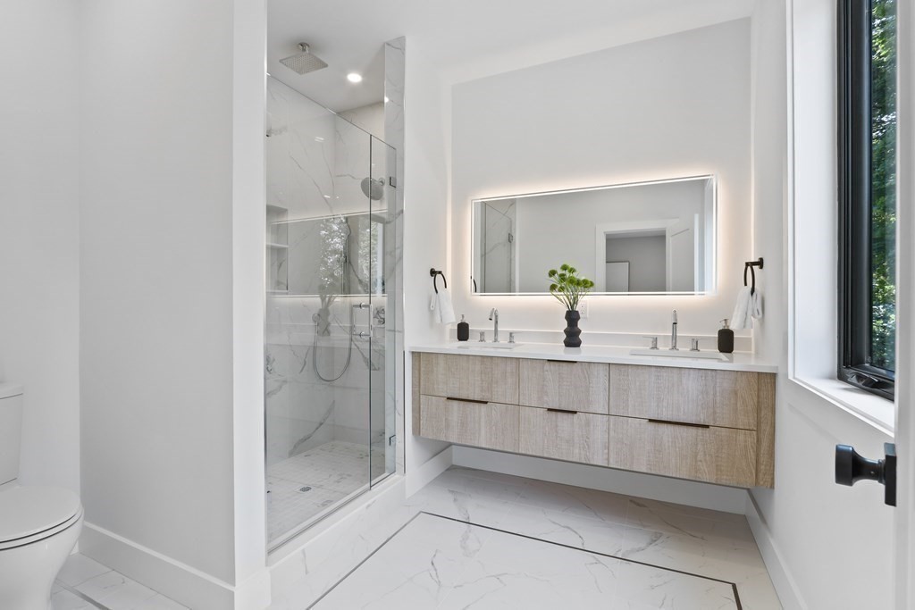70 Washington Street, Unit 70 Newton, MA 02458 - Photo 13 of 25 a bathroom with a shower sink and mirror