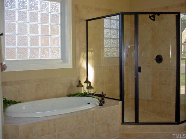 12408 Angel Road Raleigh, NC 27606 - Photo 10 of 12 a bathroom with a bathtub and a shower