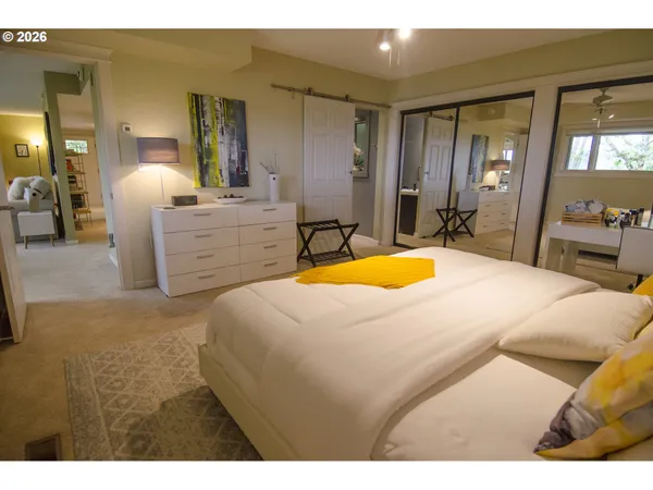 a bedroom with a bed a mirror and dresser