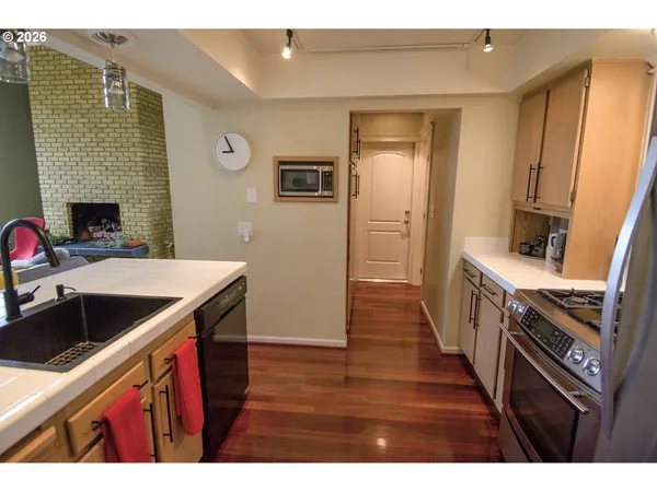 a kitchen that has a sink wooden cabinets and stainless steel appliances