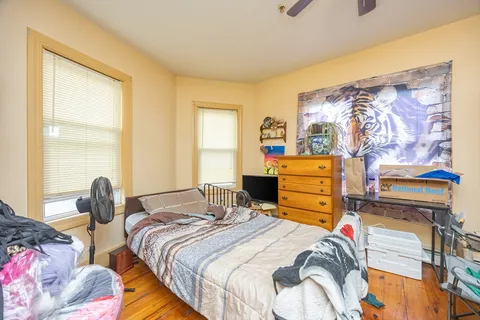 a bedroom with a bed and wooden floor