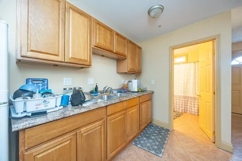 a kitchen with stainless steel appliances granite countertop a sink a stove and a refrigerator