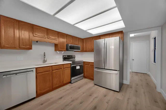 a kitchen with stainless steel appliances granite countertop a refrigerator microwave and sink
