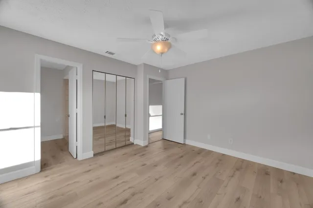 a view of an empty room with wooden floor
