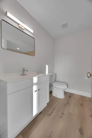 a bathroom with a toilet sink and mirror