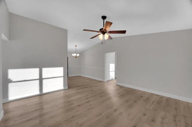 a view of room with a ceiling fan and wooden floor