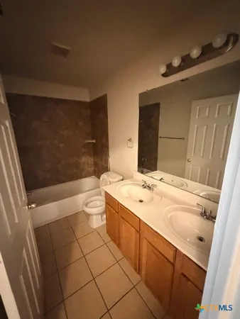 a spacious bathroom with a sink a toilet and mirror