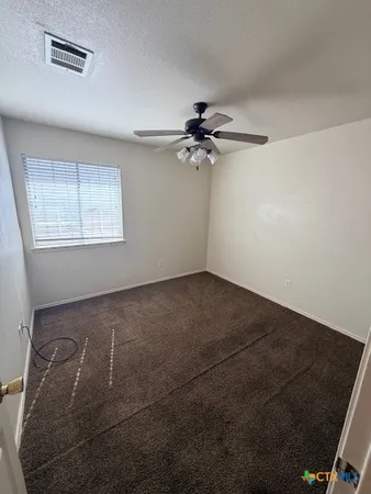 an empty room with a window and a fan