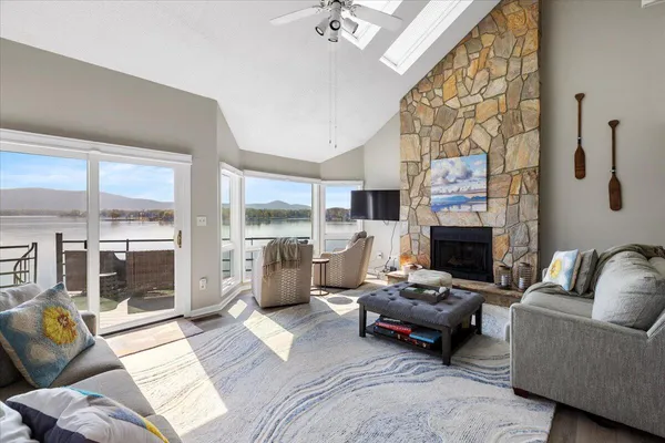a view of a patio with couches chairs dining table and chairs barbeque grill with a small yard and large trees