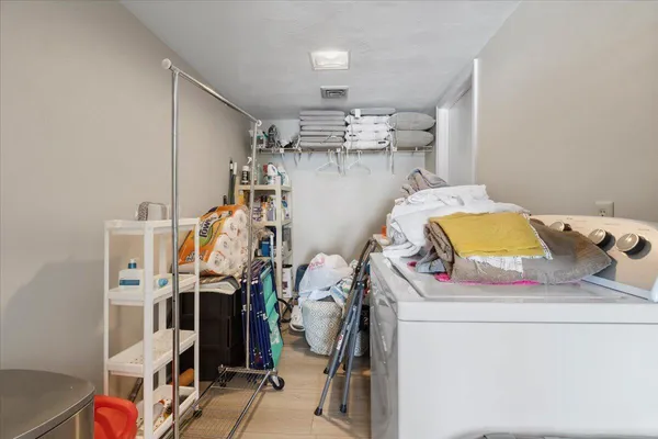 a picture of a room with a white bed and a white wall