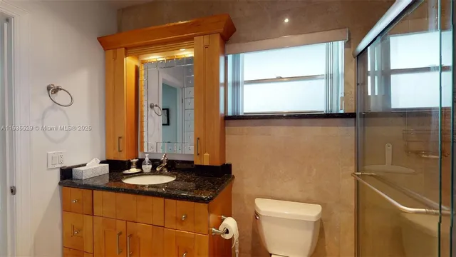 a bathroom with a sink a toilet and a mirror