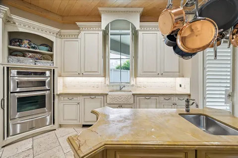 a kitchen with granite countertop a sink a stove and cabinets