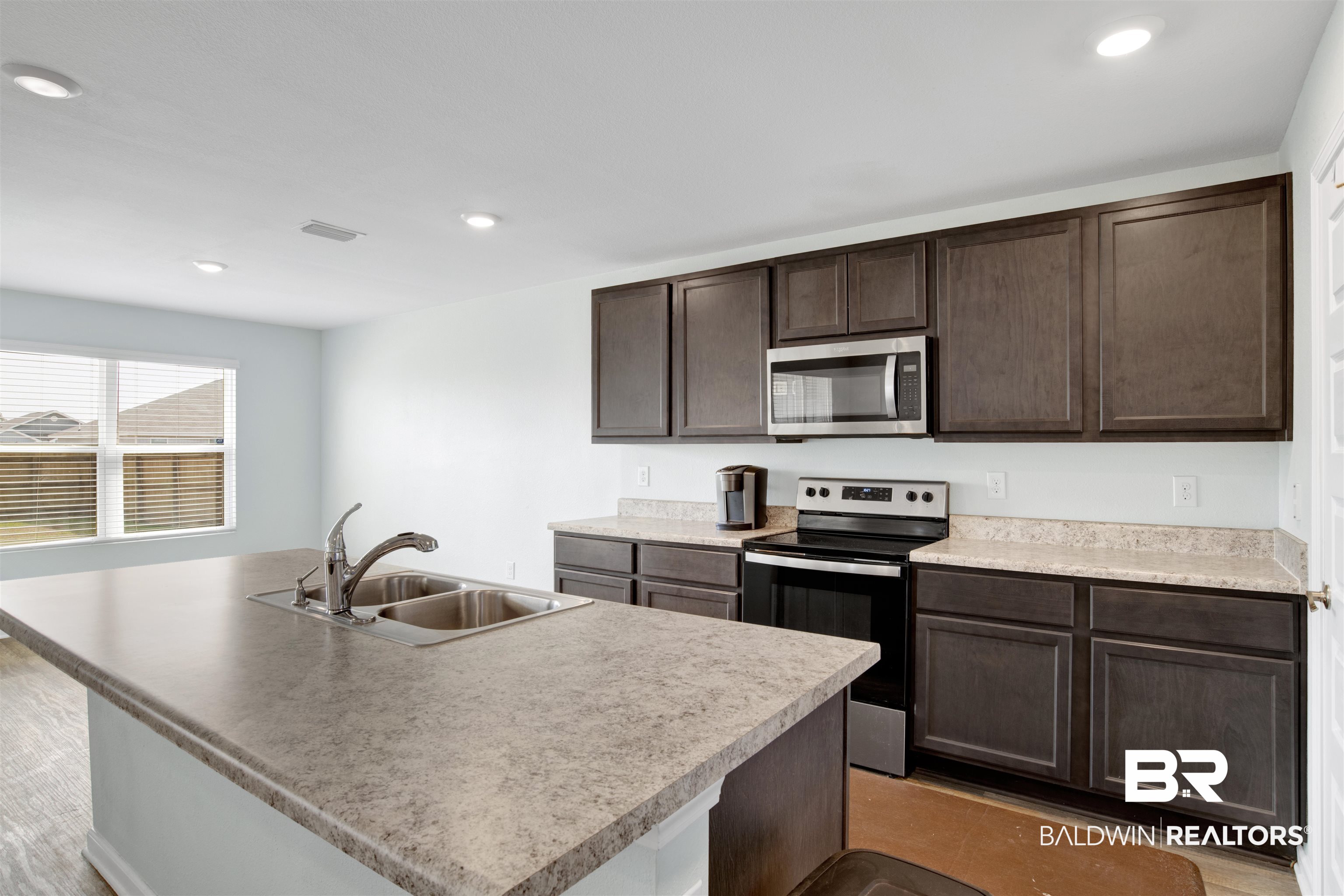 304 Hartenstein Road Foley, AL 36535 - Photo 13 of 28 Kitchen featuring a kitchen island with sink, sink, dark brown cabinetry, and appliances with stainless steel finishes
