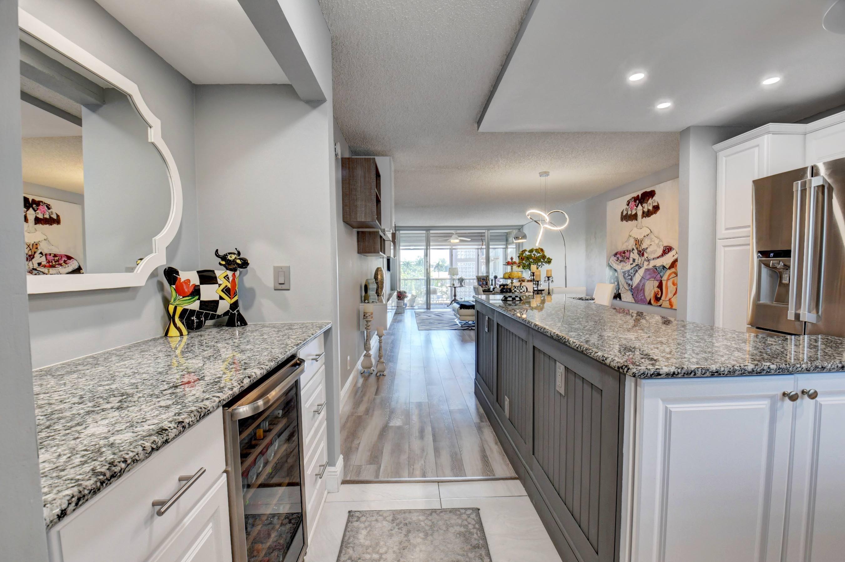 a large kitchen with stainless steel appliances granite countertop plenty wooden cabinets counter space and wooden floor