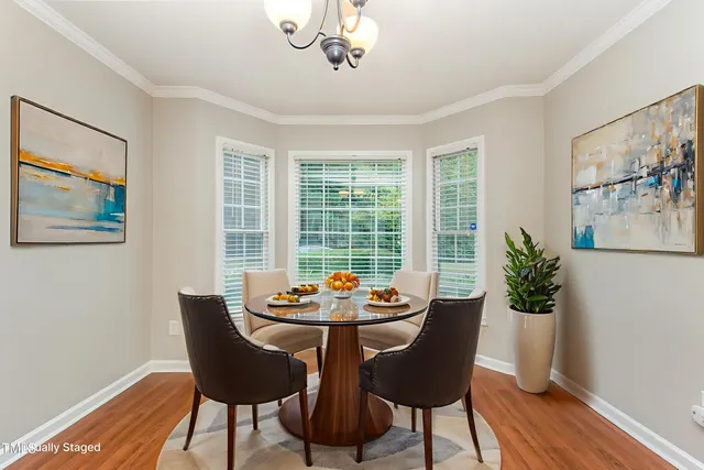 a dining room with furniture potted plants and wooden floor