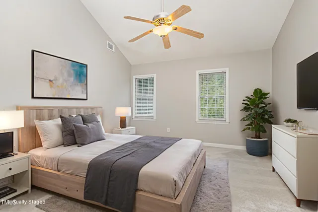a bedroom with a large bed and a potted plant
