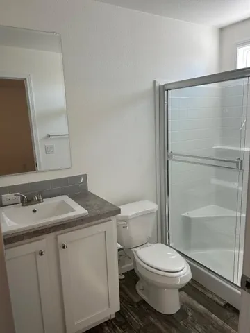 a bathroom with a granite countertop sink mirror vanity and toilet