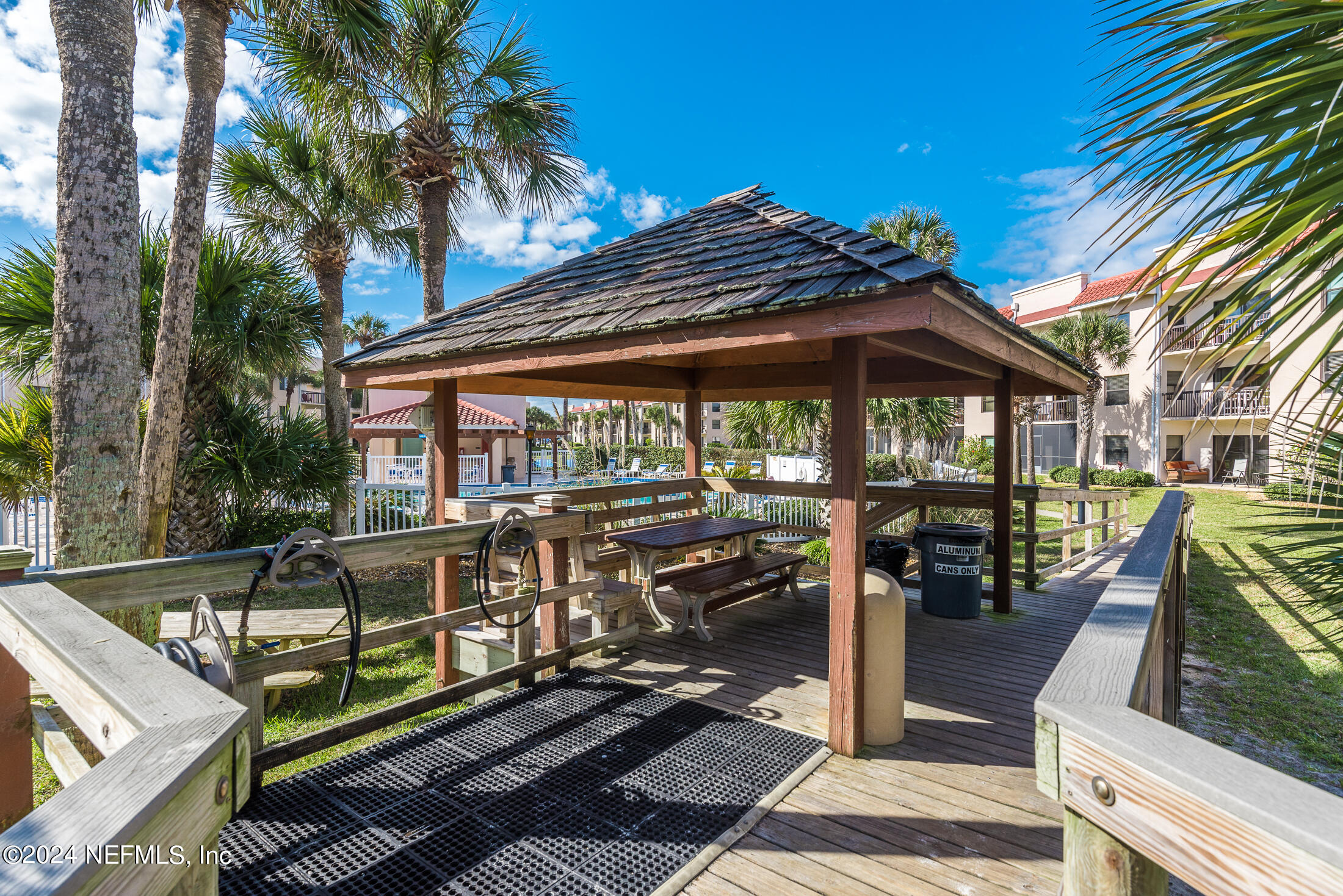 4250 A1A South, Unit Q31 (ELEVATOR) St. Augustine, FL 32080 - Photo 44 of 45 a view of a patio with table and chairs under an umbrella with a barbeque
