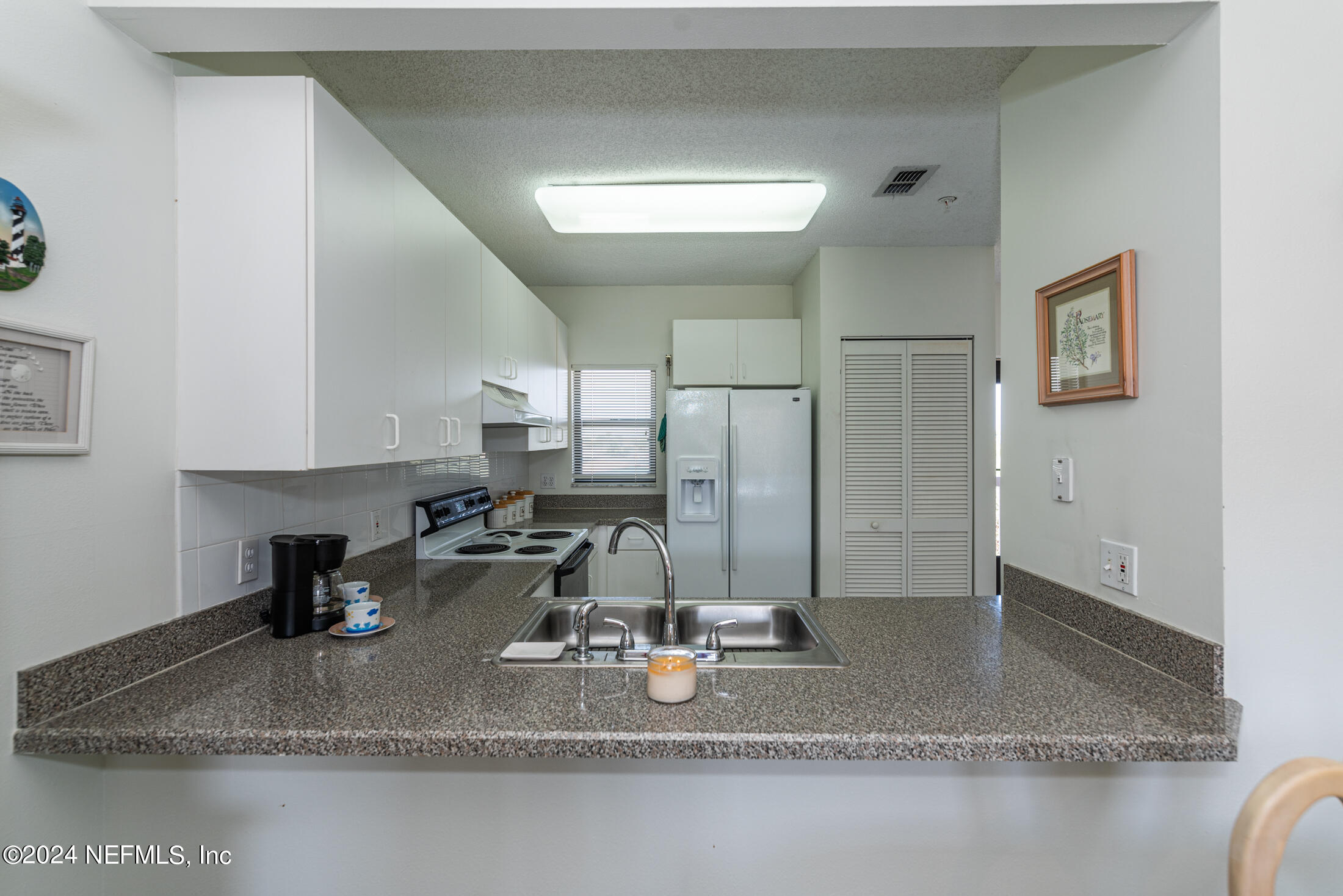 4250 A1A South, Unit Q31 (ELEVATOR) St. Augustine, FL 32080 - Photo 9 of 45 a kitchen with a refrigerator a sink and cabinets