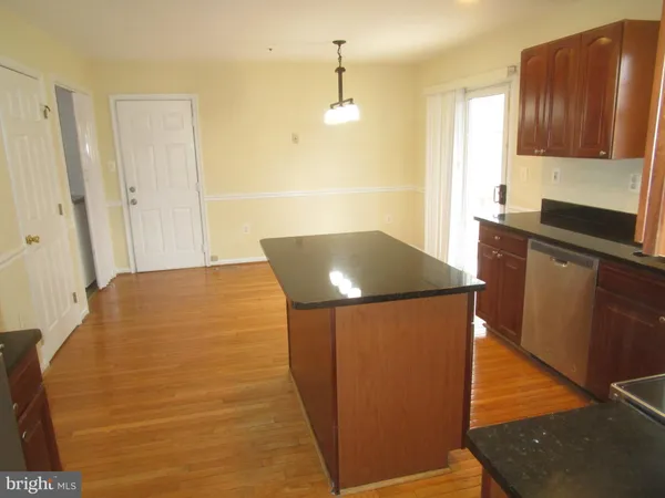 a kitchen with stainless steel appliances kitchen island granite countertop wooden cabinets and a granite counter tops