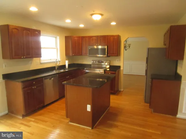 a kitchen with stainless steel appliances granite countertop a stove a refrigerator a sink and a oven