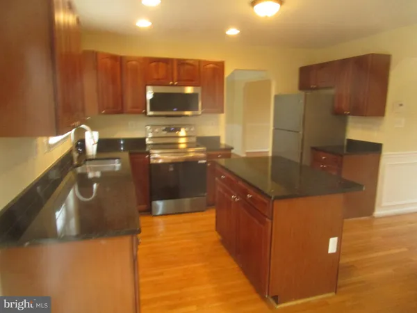a kitchen with stainless steel appliances granite countertop a sink a stove and a refrigerator
