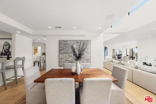 a very nice looking dining room with kitchen island a large window cabinets and stainless steel appliances