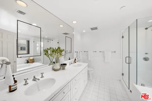 a bathroom with double vanity sinks a shower and a mirror