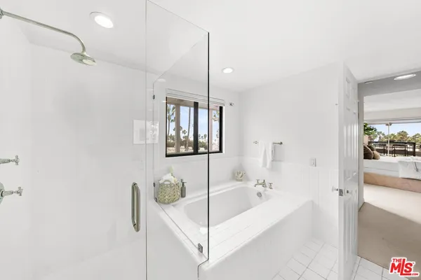 a bathroom with a bathtub and chandelier