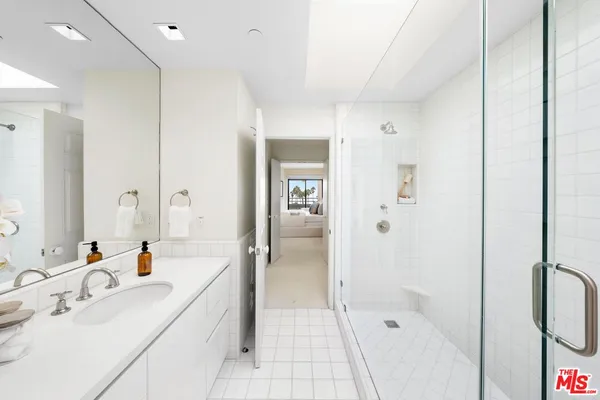 a bathroom with a bathtub shower sink and mirror