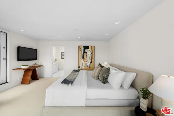 a bedroom with a bed and a flat screen tv