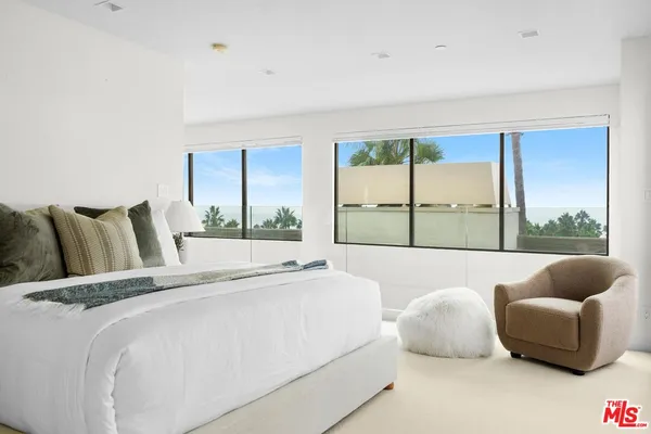 a bed sitting in a bedroom next to a window