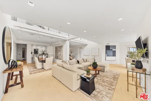 a living room with furniture a flat screen tv and a large window