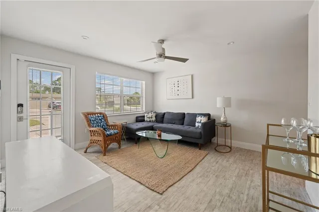 a living room with furniture a rug and white walls