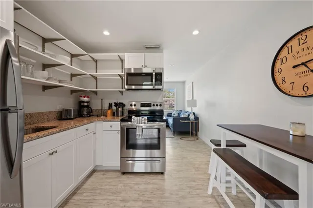 a kitchen with stainless steel appliances granite countertop a refrigerator and a stove top oven