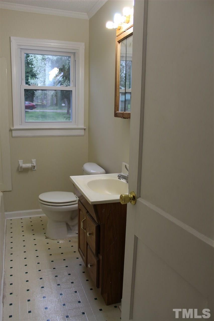 500 Grovemont Road Raleigh, NC 27603 - Photo 12 of 18 a bathroom with a sink a toilet a mirror and a window