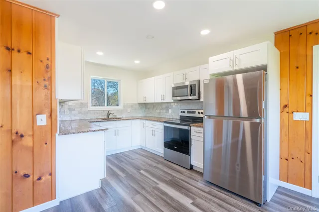 a view of a hallway with wooden floor and windows
