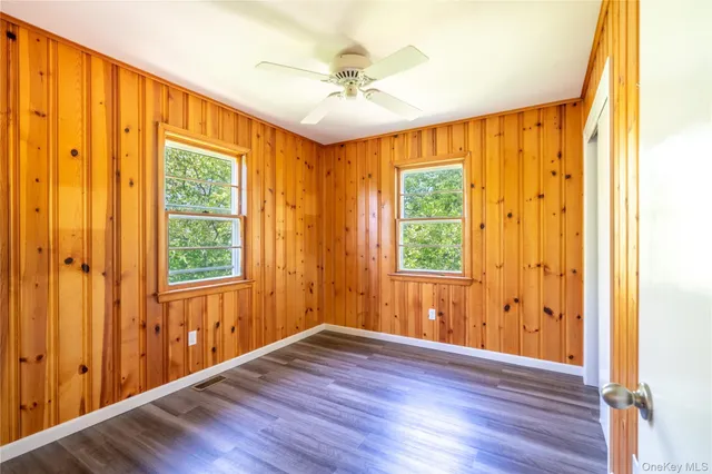 a view of hallway with window and wooden floor