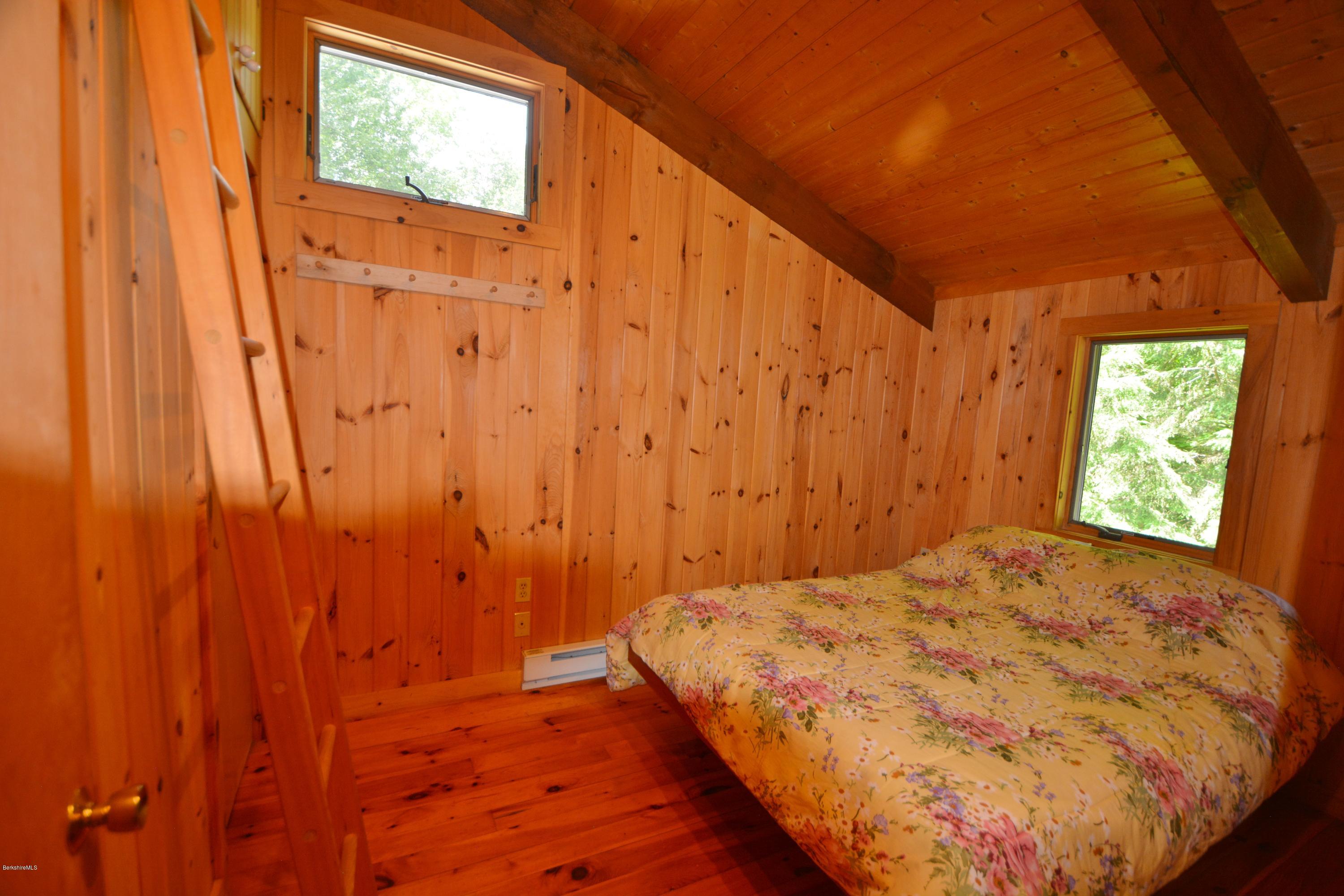 395 Bonny Rigg Hill Road Becket, MA 01223 - Photo 14 of 26 a bed sitting in a bedroom next to a window