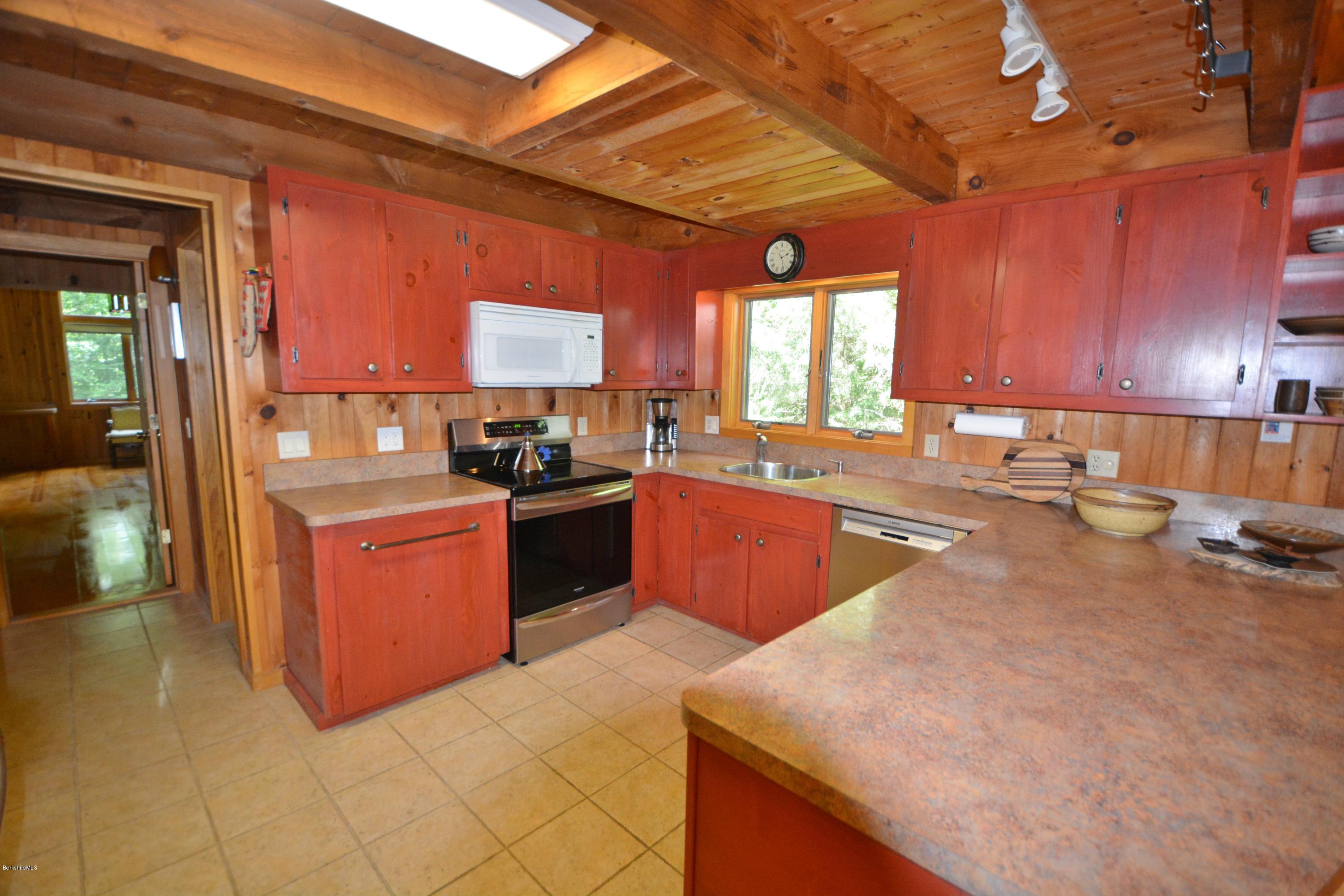 395 Bonny Rigg Hill Road Becket, MA 01223 - Photo 8 of 26 a kitchen with stainless steel appliances granite countertop a sink counter space cabinets and a large window