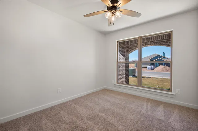 an empty room with a window and a ceiling fan